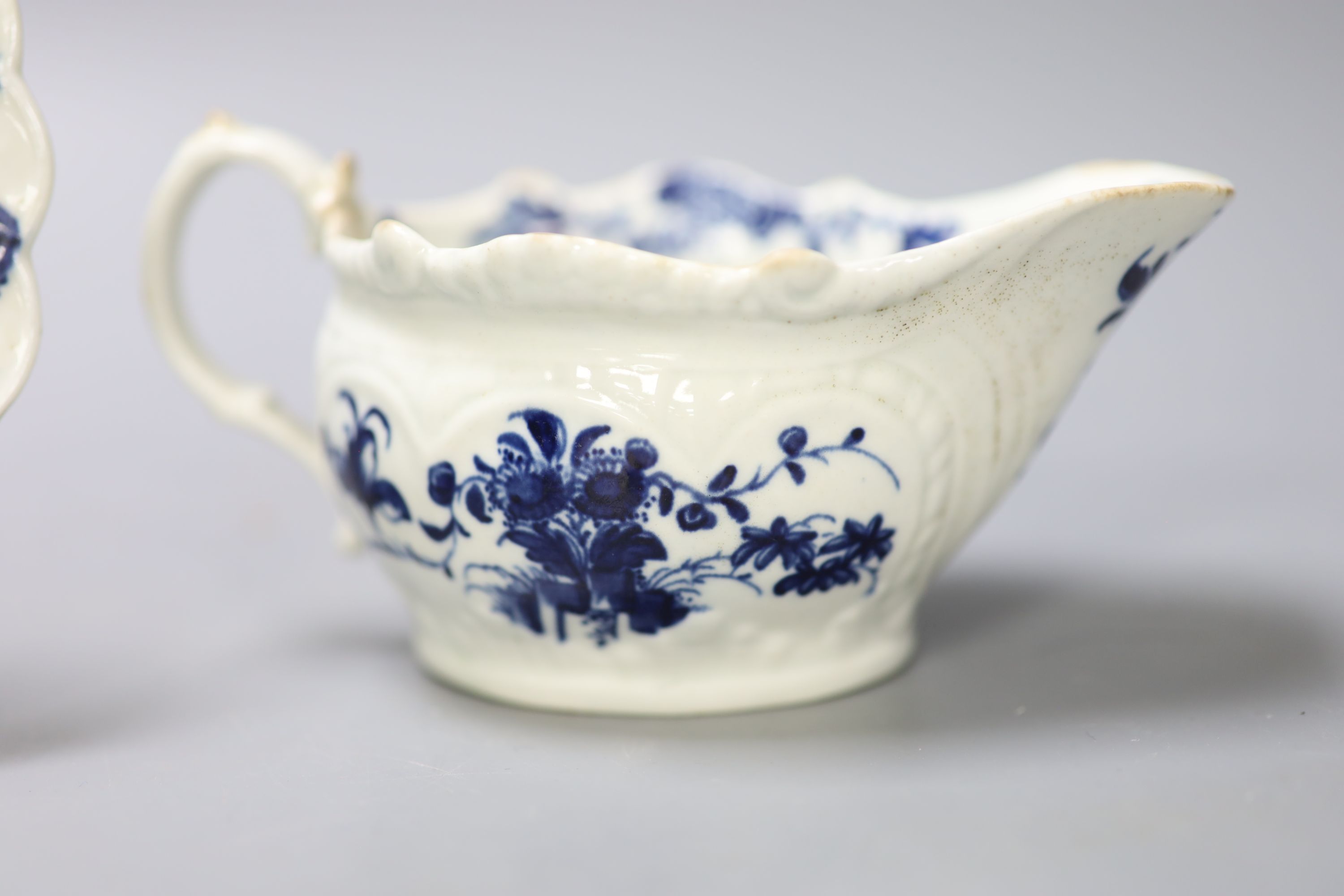 A Worcester small sauceboat painted with Two Porter Landscape in moulded panel, flowers verso, c.1760